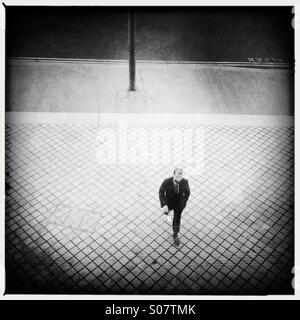 Fashionable young Man waking on a patterned pavement in London Stock Photo