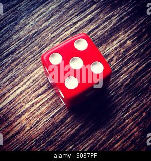 Red dice showing number 5 Stock Photo