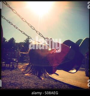 Mid-summer fun on a swing. Stock Photo