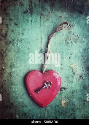 Red wooden heart and a key Stock Photo