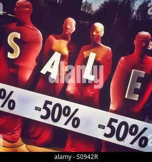 A shop window displaying sales promotions is seen. Stock Photo