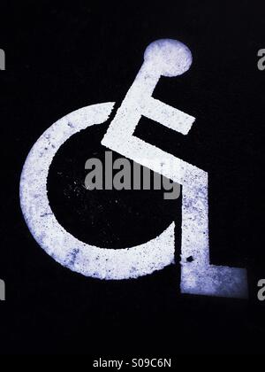 Handicapped / disabled  parking sign painted on the road marking a parking space reserved for disabled people. Stock Photo