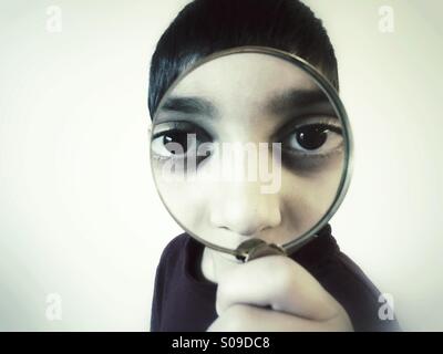 Little boy holding magnifying glass Stock Photo