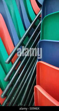 Colourful plastic chairs stacked. Stock Photo