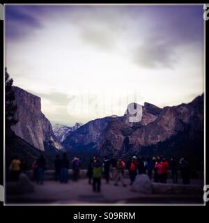 A busload of Asian tourists look at Yosemite Valley from the famous Tunnel View vista on Wawona Road during fall. Yosemite Valley, Yosemite National Park, Mariposa County, California, USA Stock Photo