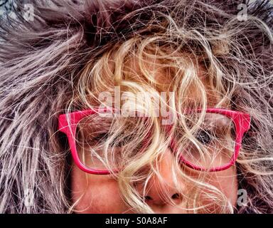 Young Girl wearing furry hood with face obscured by curly blind hair Stock Photo