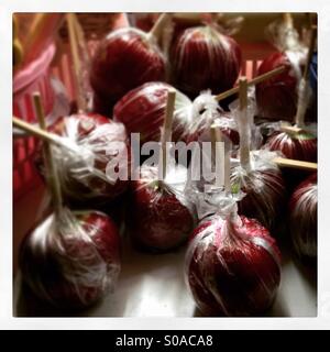 Toffee apples, Candy apples, Pommes d'amour on sale. Red, sticky and tasty. Stock Photo