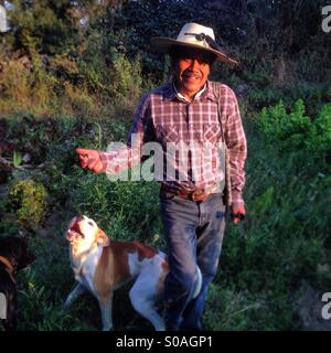 Organic farmer Tomás Villanueva walks with his dog in Tepetlixpa, Mexico State, Mexico. GMO seeds are threatening to contaminate native varieties of corn in México. Stock Photo