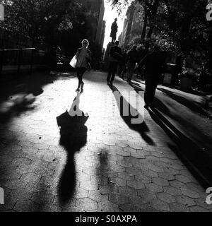 Peoples shadows as walk through Union Square Park in Manhattan. Stock Photo