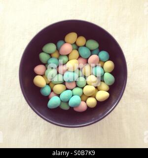 Bowl of sugar-coated chocolate Easter eggs, with subtle dreamy filter. Stock Photo