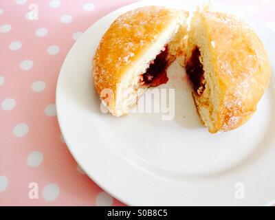 Jam filled doughnut on a white plate Stock Photo