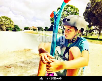 A boys with his scooter at the skatepark Stock Photo