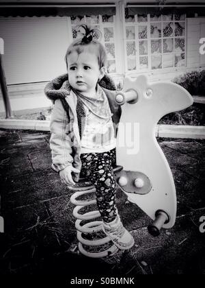Small baby girl on playground outdoor in black and white Stock Photo