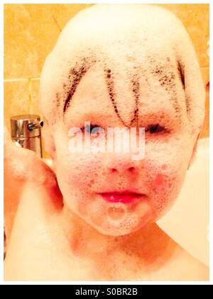 Boy with bath bubbles on his face Stock Photo