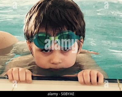 4 years old boy in swimming pool with swimming glasses Stock Photo