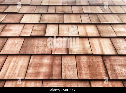 New, pre-weathered, sustainably sourced Western Red cedar shingles laid on a roof. Can also be used as building cladding. Stock Photo
