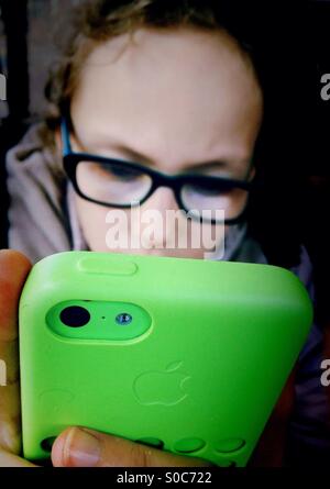 Young girl playing on green iPhone Stock Photo