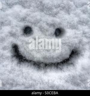 Don't worry, be happy - a smiley face drawn on a snowy car windshield Stock Photo