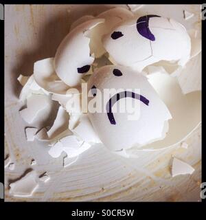 Broken Eggshells with sad faces Stock Photo