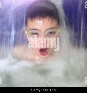 Boy in swimming pool and waterfall Stock Photo