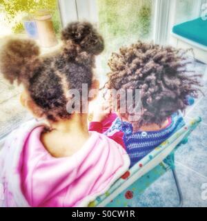 Two children sitting on a chair. Stock Photo