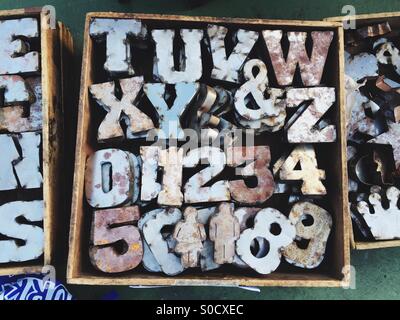 Metal letters, numbers and figures are for sale at a flea market. Stock Photo