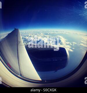 Looking out over the wing of a plane at the curvature of the earth Stock Photo