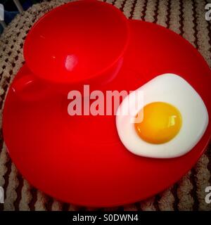 A toy cup, plate and fried egg. Stock Photo