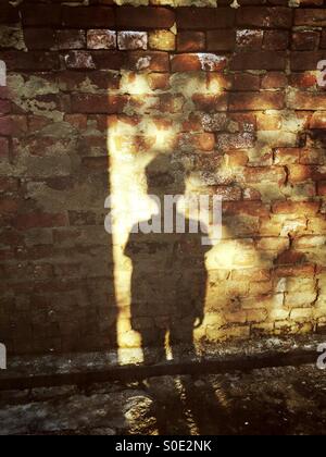 Shadow of a little boy on a brick wall
