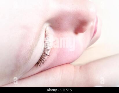 Young girl sleeping with her head resting on her hand Stock Photo