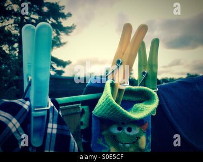 Close up of pegs holding clothes on a washing line. Stock Photo