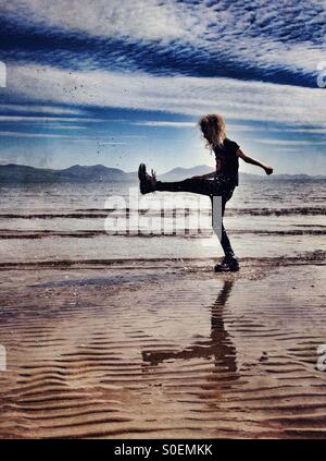 Young girl playing in sea at Newborough beach on Anglesey