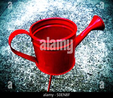 Red watering can on a stick Stock Photo