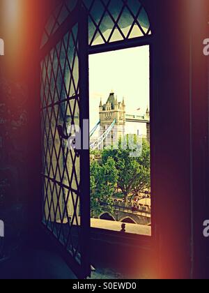 Tower Bridge as seen through a window in the White Tower. Tower of London Stock Photo