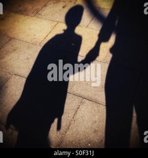 Shadow of a mother and her child walking together on the street in Barcelona