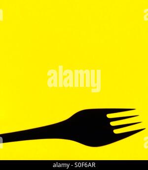 Fork on yellow background Stock Photo