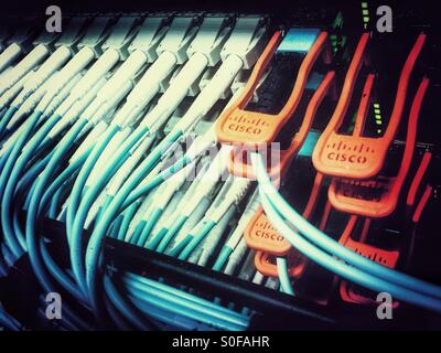 Close up of fiber optic network cables urged into LAN switch. Stock Photo