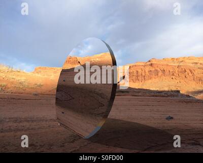Large round mirror in desert Stock Photo