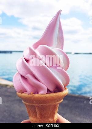 Strawberry and vanilla soft serve ice cream by the sea Stock Photo