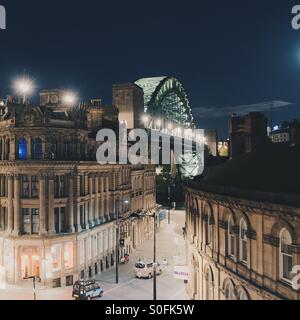 A view of the Tyne bridge in Newcastle looking down a city street at night