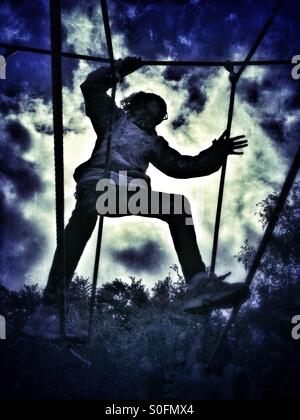 Girl on rope climbing frame Stock Photo