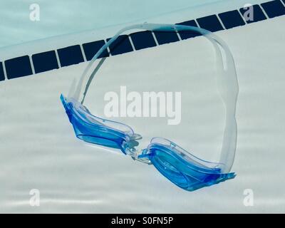 A pair of swimming goggles underwater in a pool Stock Photo
