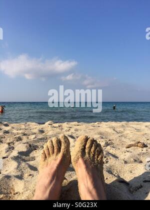 Sandy feet on beach Stock Photo