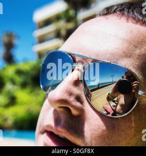 Photographers reflection in sunglasses