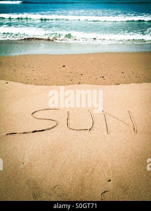 The word Sun written in the sand Stock Photo