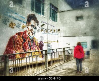 Woman viewing artwork inspired by George Orwell on Southwold Pier, Suffolk, England. The work was created by street artist 'Pure Evil' (Charlie Uzzel-Edwards). Stock Photo