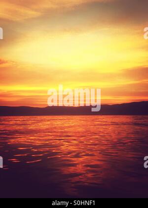 Fiery summer sunset over lake. Stock Photo