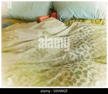 Small child sleeping in a big bed Stock Photo