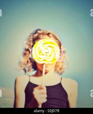 Young girl holding candy lolly in front of her face Stock Photo