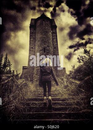 Young girl walking up stone steps of derelict folly (pigeon tower) in Rivington, Lancashire Stock Photo